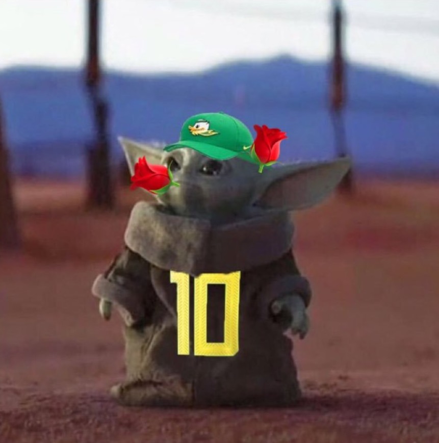 PHOTO Baby Yoda With A Rose In His Mouth With Oregon Ducks Jersey Because He's Going To The Rose Bowl